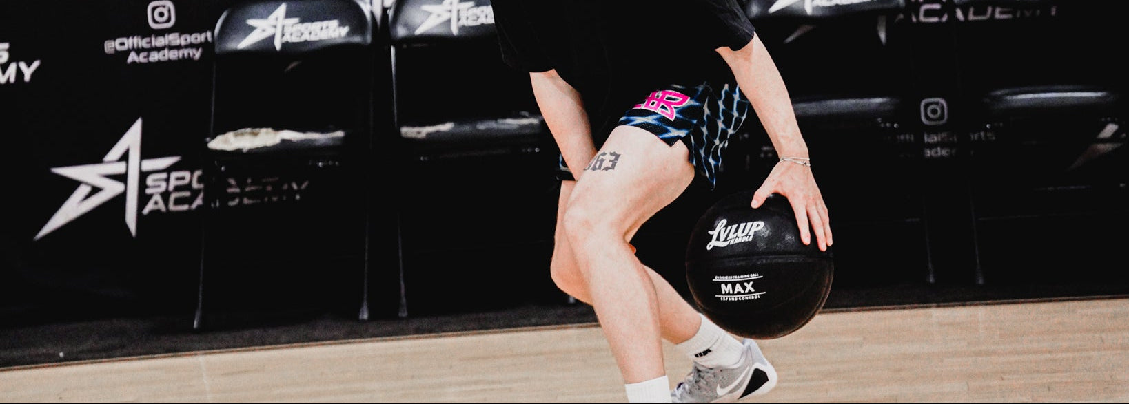 Person holding a basketball in front of a branded backdrop